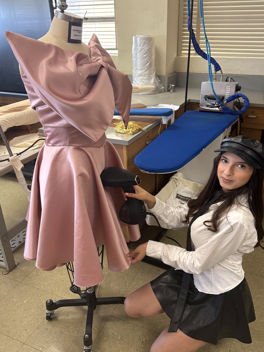 Audriana Levian steaming a rose satin gown in the atelier
